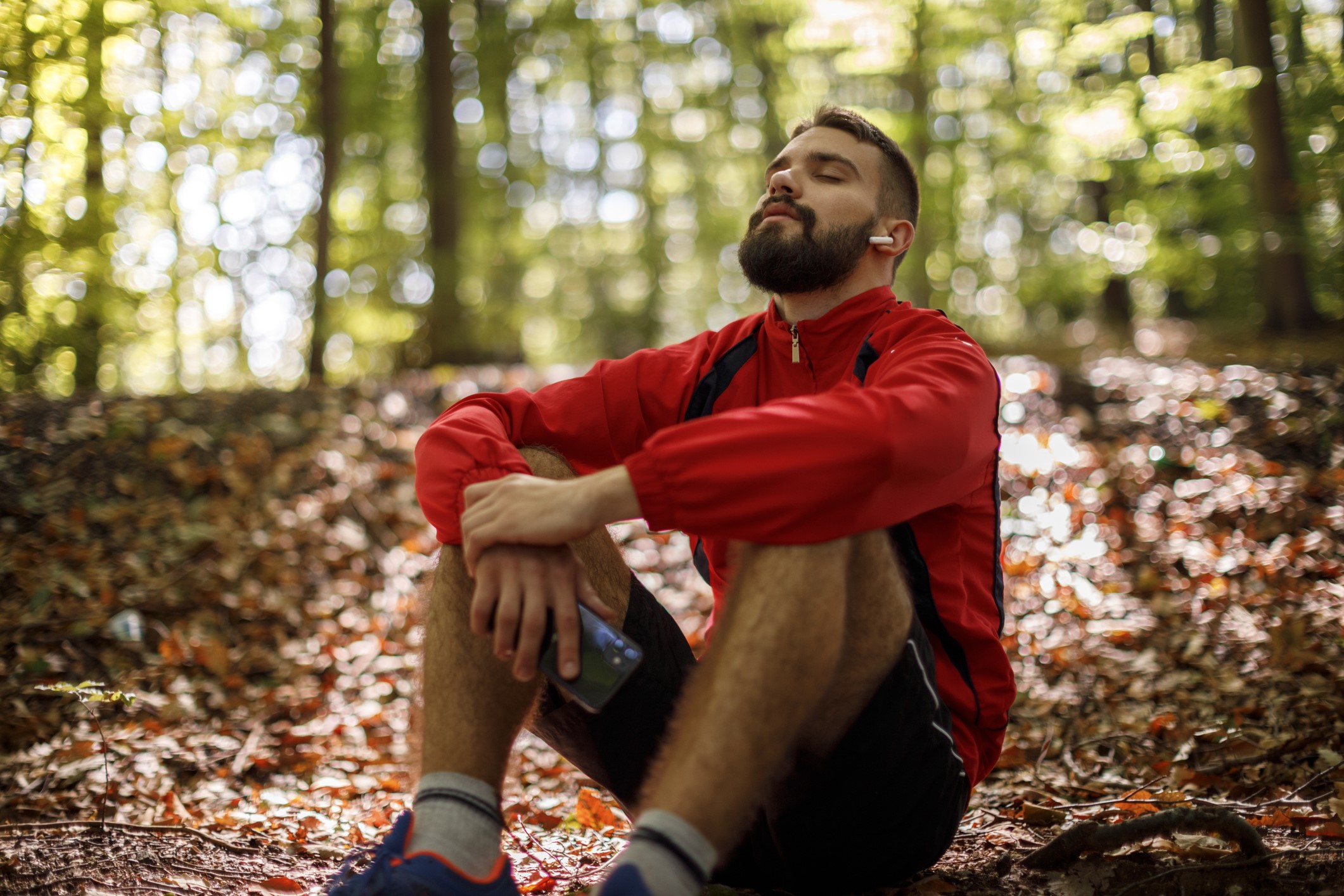 Photo of man relaxing in the woods after a hike.